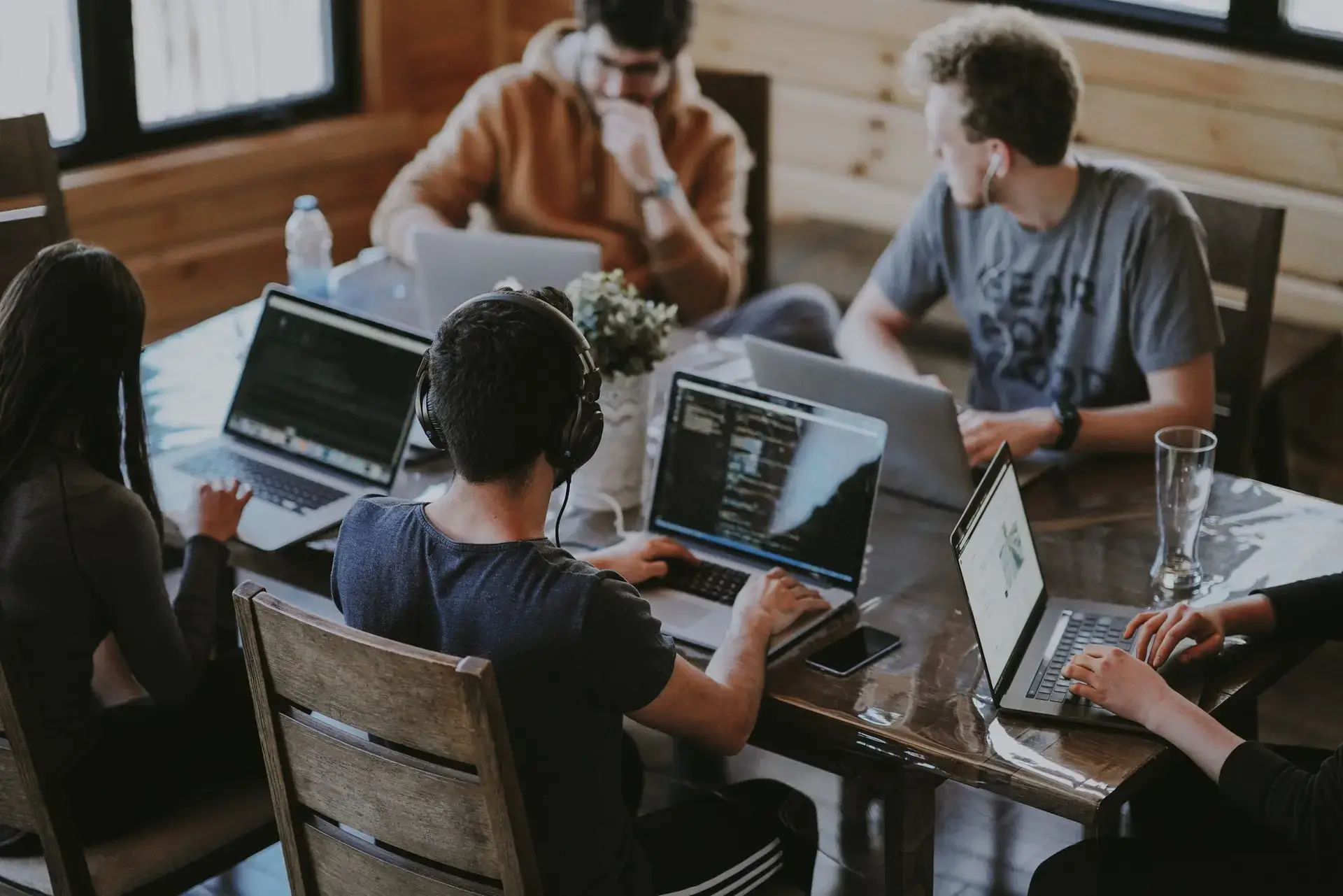 Um grupo de TI trabalhando em laptops sobre a mesma mesa